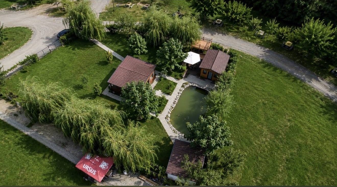 Holzhütten rund um einen Teich, aus der Drohnenperspektive