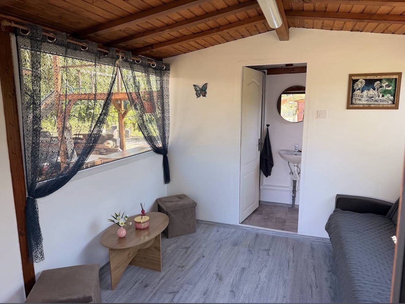 Ein Raum in Holz und Weiß mit Sofa, Couchtisch und eigenem Bad